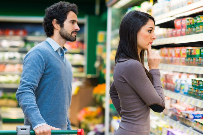 42245464 - young couple choosing the best food in a supermarket
