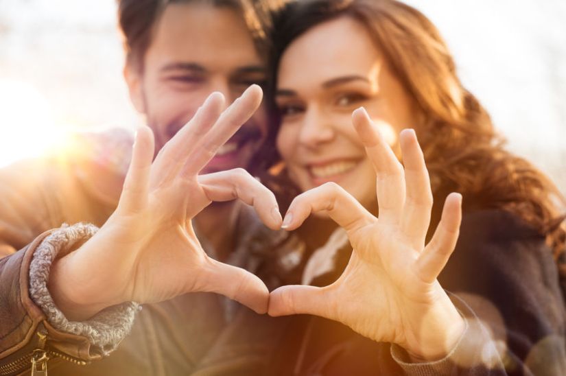 38774765 - closeup of couple making heart shape with hands